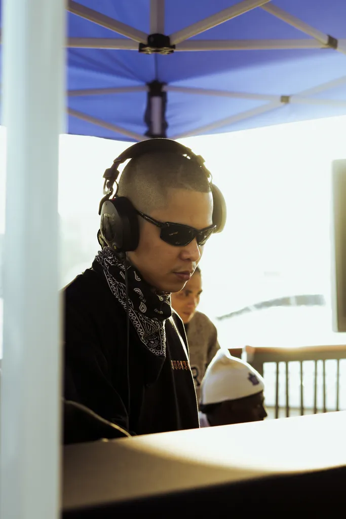 Man in headphones and sunglasses under a blue canopy